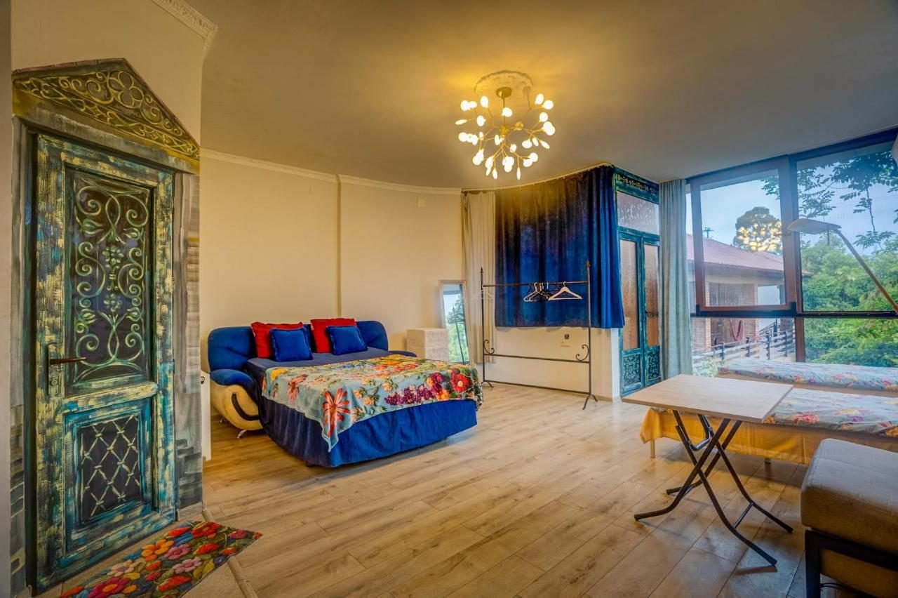 Family room with a large bed, sofa and a carved wooden door